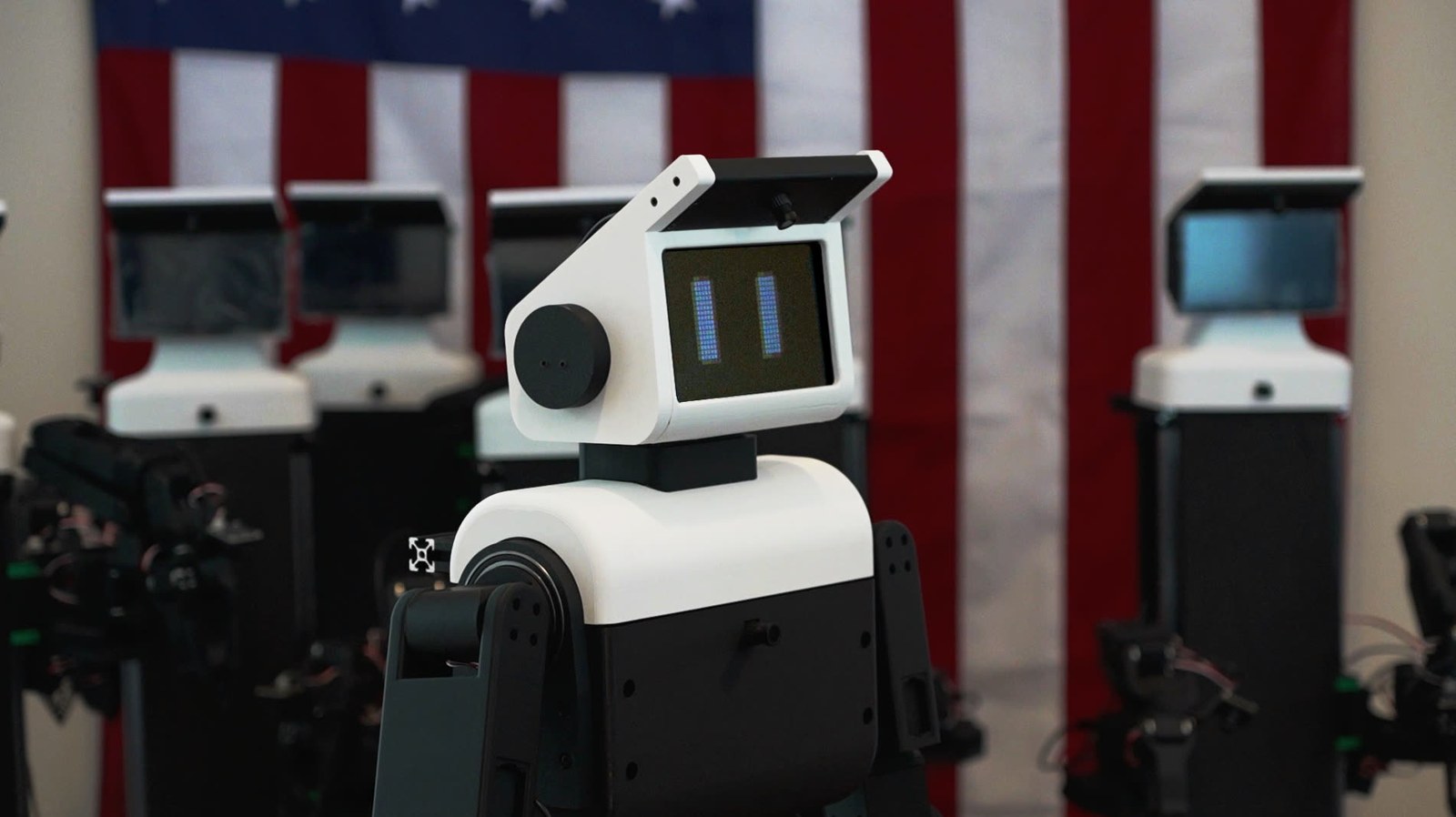 A Nori A3 robot in the company's San Francisco assembly space, with more robot units behind it and an American flag on the wall