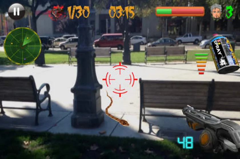 Augmented reality game view of a park with a crosshair, timers and spider icons.