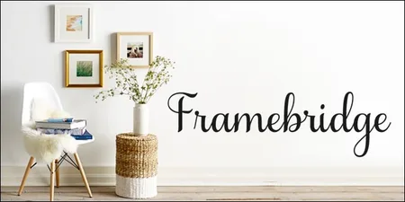 Room with framed pictures, a white chair and a 'Framebridge' script wordmark.